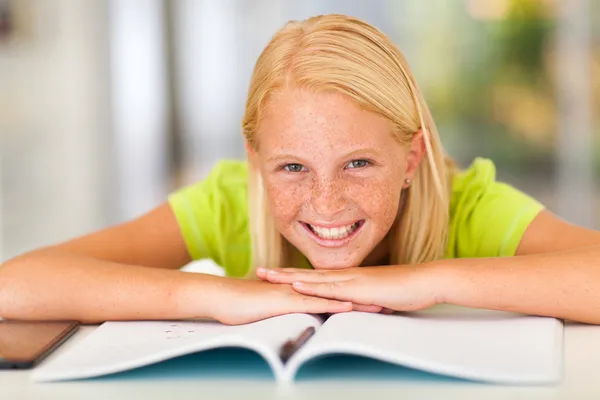 Счастливая девочка-подросток лежит на книжке — стоковое фото