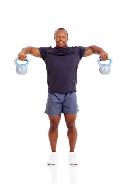 Africano hombre haciendo ejercicio con hervidor de agua campanas —  Fotos de Stock