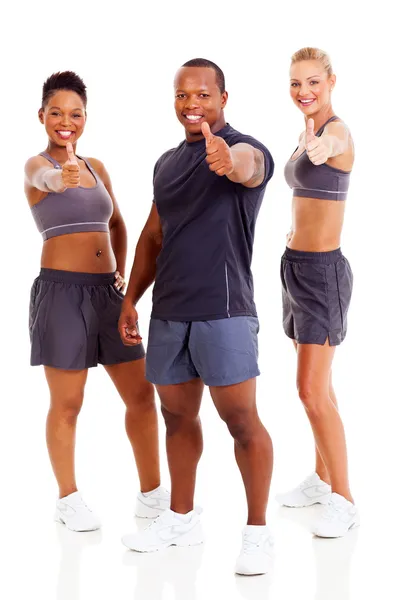 Grupo de instructores de gimnasio felices dando pulgares hacia arriba — Foto de Stock