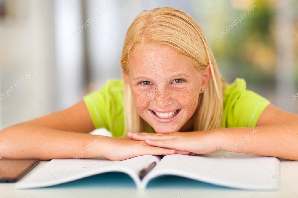 happy teen girl lying on book