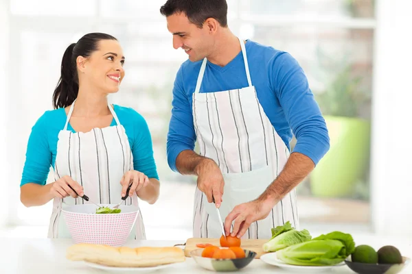 Casal amoroso conversando enquanto prepara a salada — Fotografia de Stock