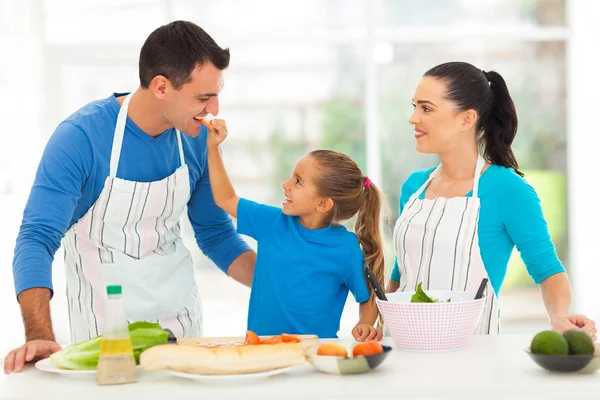 Linda hija alimentación padre un pedazo de tomate —  Fotos de Stock