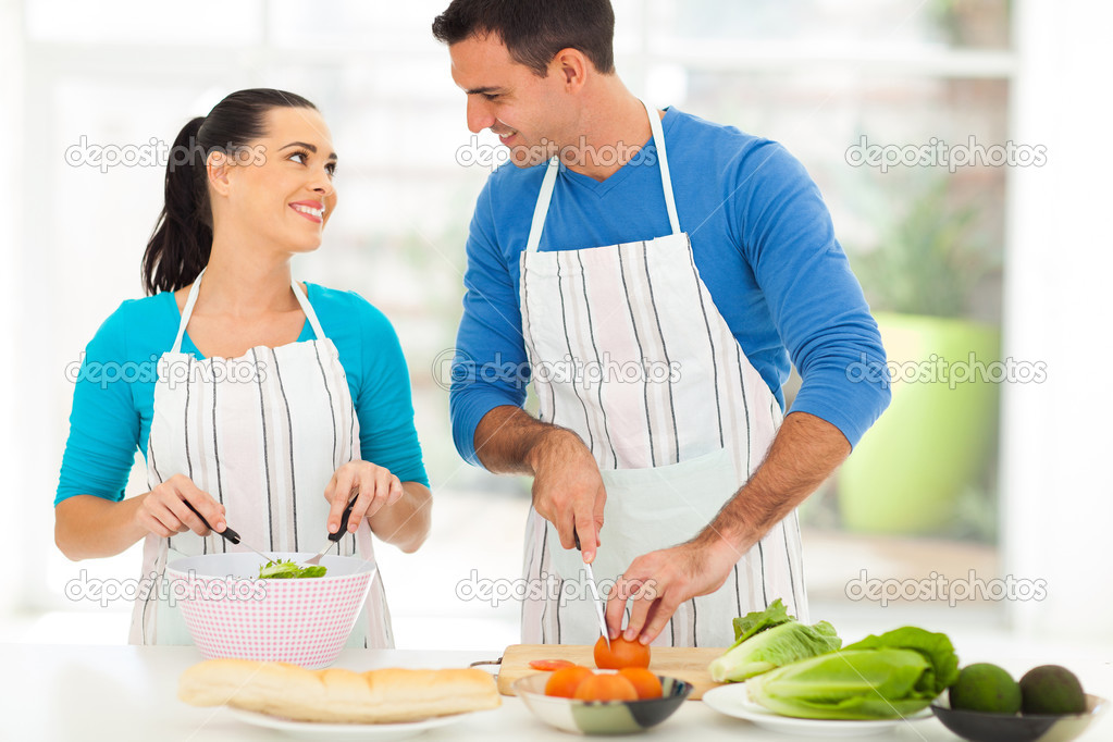 loving couple chatting while preparing salad