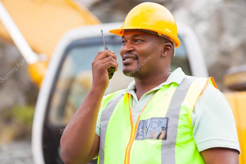 afro american industrial worker talking on walkie-talkie