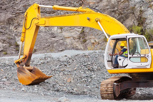 Road construction worker operating excavator — Stock Photo, Image