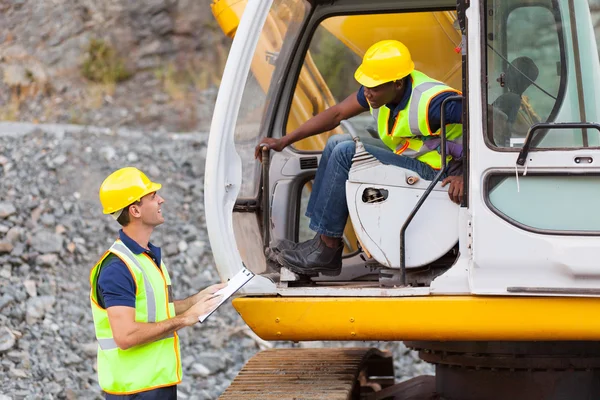 Construction foreman talking excavator operator — Stock Photo, Image
