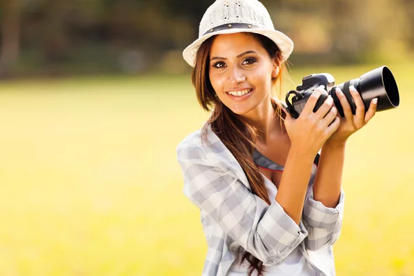 Jovem atraente segurando câmera ao ar livre — Fotografia de Stock
