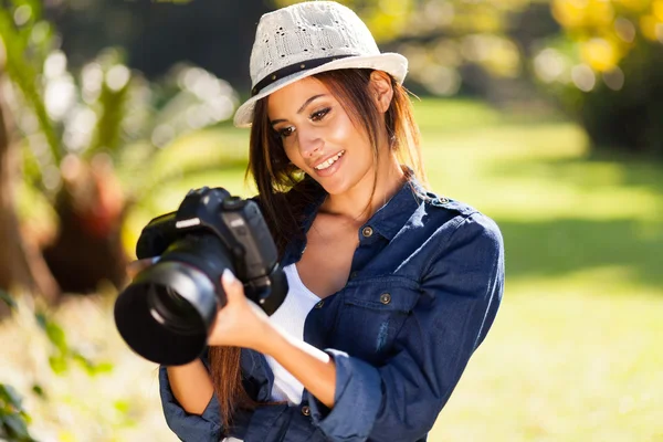 Jonge vrouwelijke fotograaf foto's op de camera te controleren — Stockfoto