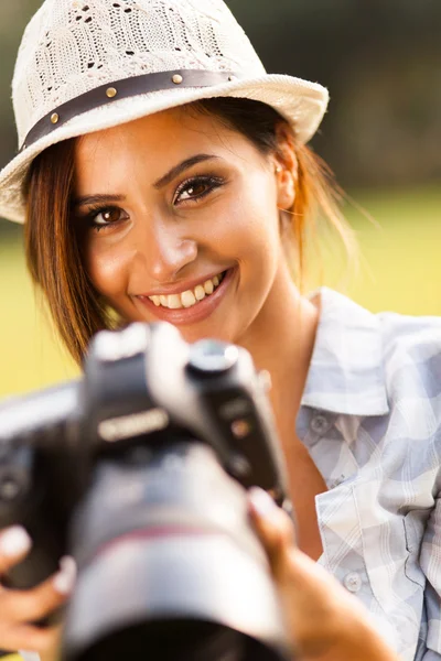 Beautiful young woman holding camera outdoors Stock Picture