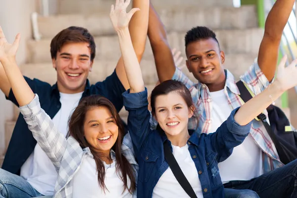 Opgewonden middelbare scholieren met uitgestrekte armen — Stockfoto