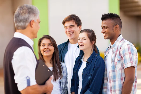 Midden leeftijd leraar gesprek met studenten — Stockfoto