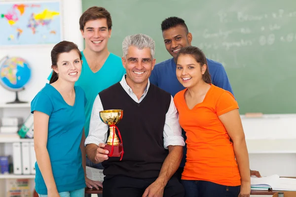 Senior docent en middelbare scholieren met trofee — Stockfoto