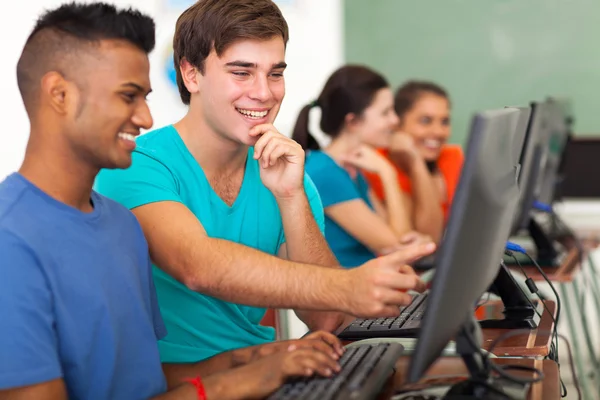 Estudante do ensino médio masculino ajudando colega de classe com computador — Fotografia de Stock