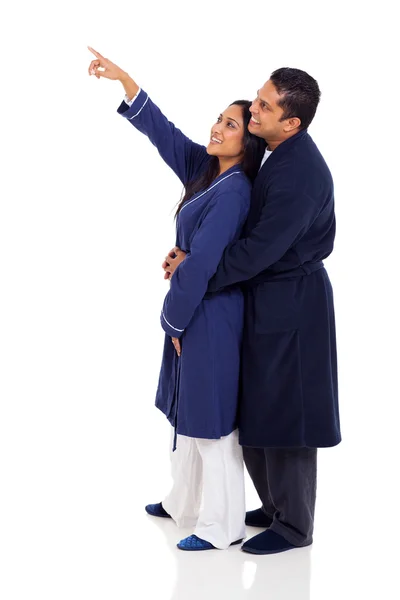 Indian couple in nightgowns pointing at copy space — Stock Photo, Image