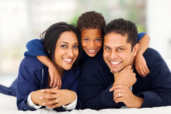 Little indian boy hugging his parents on bed — Stock Photo, Image