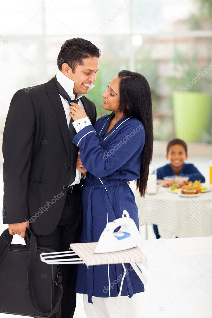 loving wife helping husband with his tie