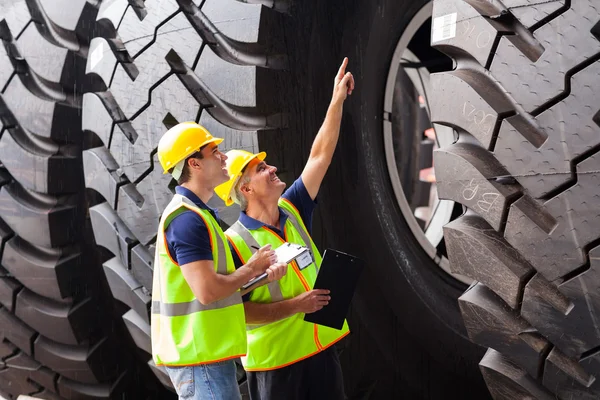 Shipping company workers checking industrial tires — Stock Photo, Image