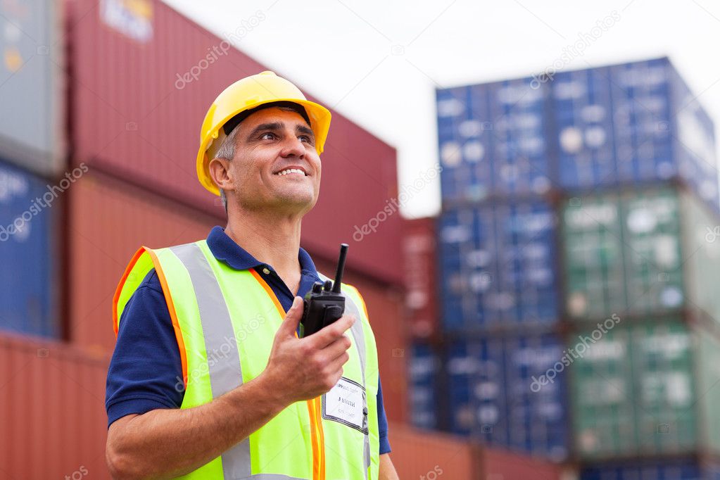 Middle aged warehouse worker holding radio