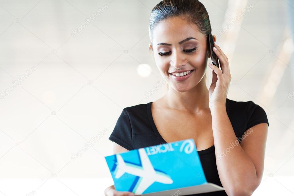 young woman talking on mobile phone at airport
