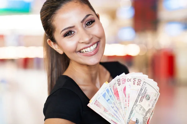 Young woman holding fan of cash in casino — Stock Photo, Image