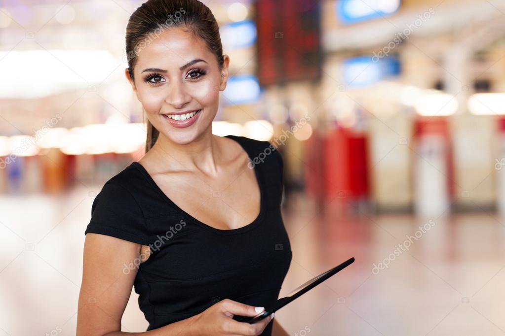 young woman holding tablet computer at airport