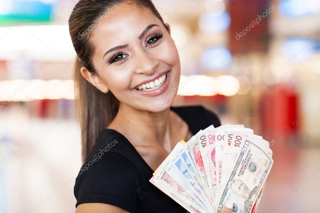young woman holding fan of cash in casino