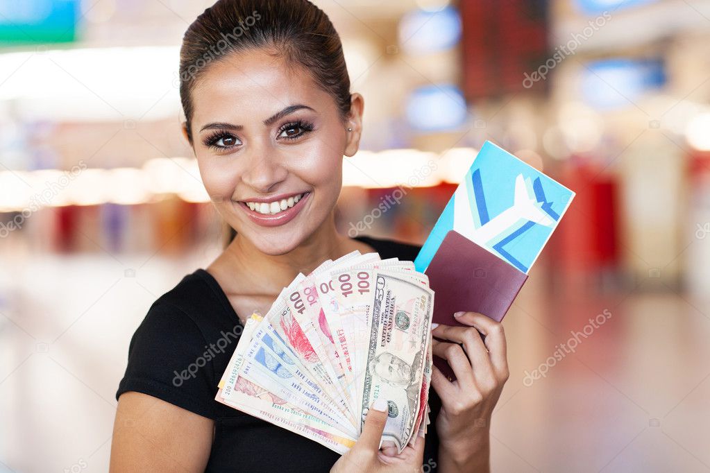 young woman holding passport, air ticket and cash