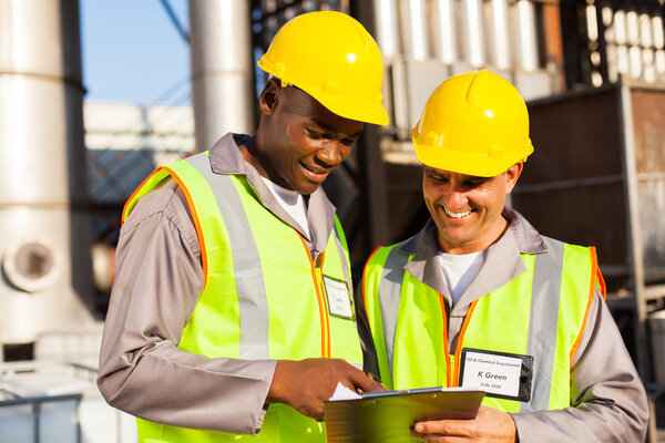 Тяжелые рабочие, работающие на заводе
