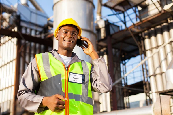 Afrikansk olja chemical arbetstagaren talar i mobiltelefon — Stockfoto