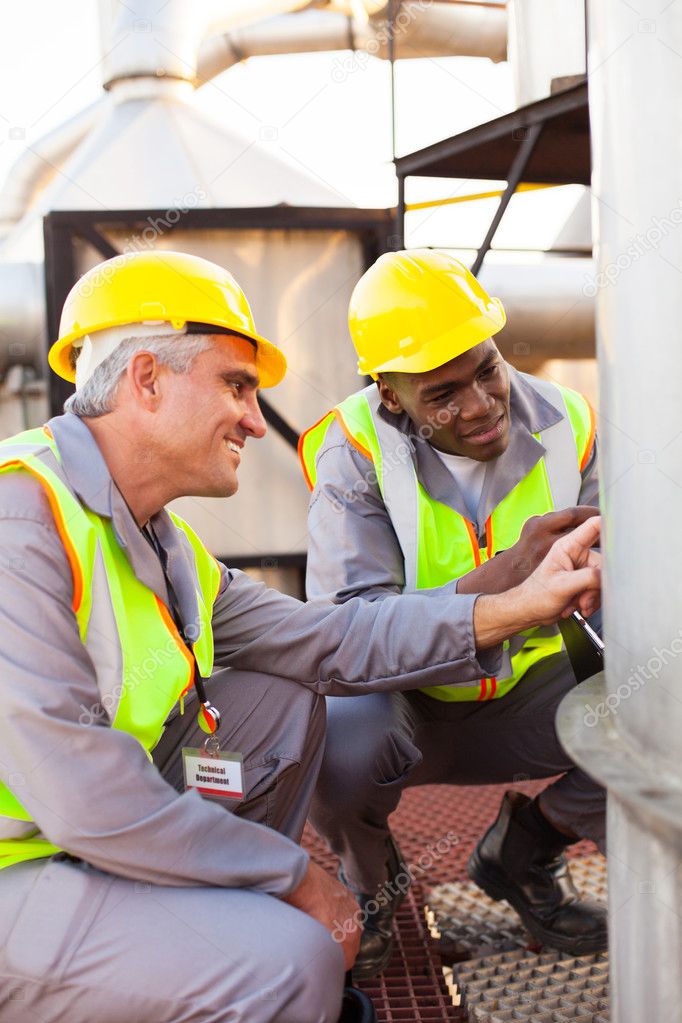 Petrochemical technicians inspecting fuel tank