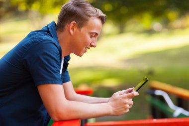 sevimli genç çocuk açık havada tablet bilgisayar kullanma