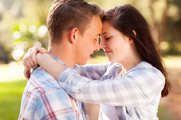 Young teenage couple hugging with eyes closed — Stock Photo, Image