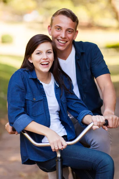 Casal adolescente em uma bicicleta — Fotografia de Stock