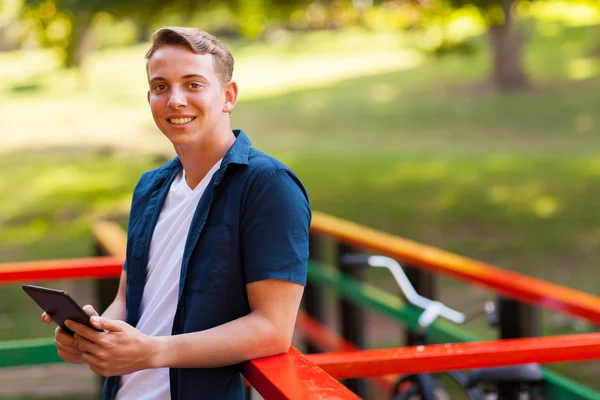 Tiener jongen buiten houden van tablet pc — Stockfoto