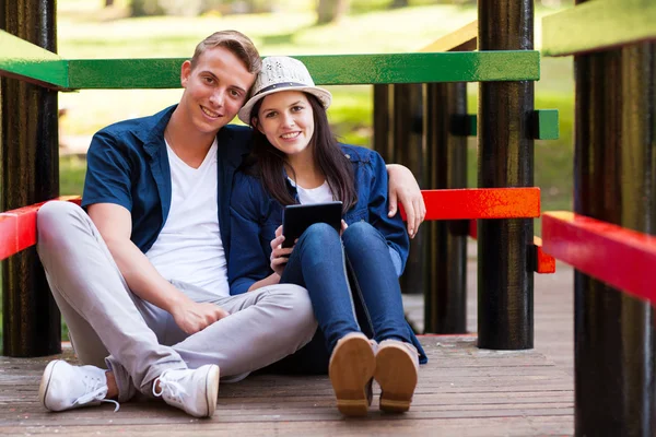 Loving teen couple with tablet computer outdoors — Stock Photo, Image