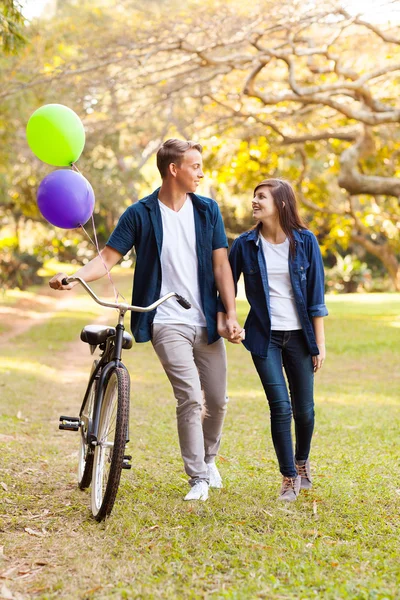 Cute teenage couple with bicycle outdoors — Stock Photo, Image
