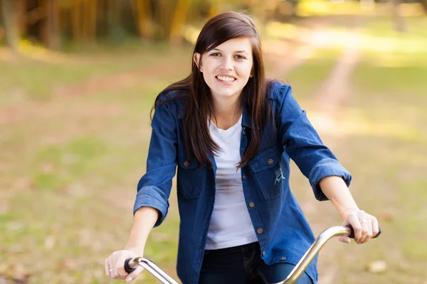 Pretty teenage girl riding bike in the park — Stock Photo, Image