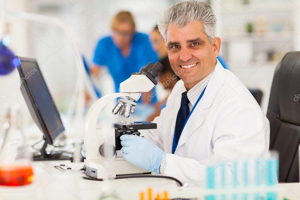 middle aged scientist using microscope