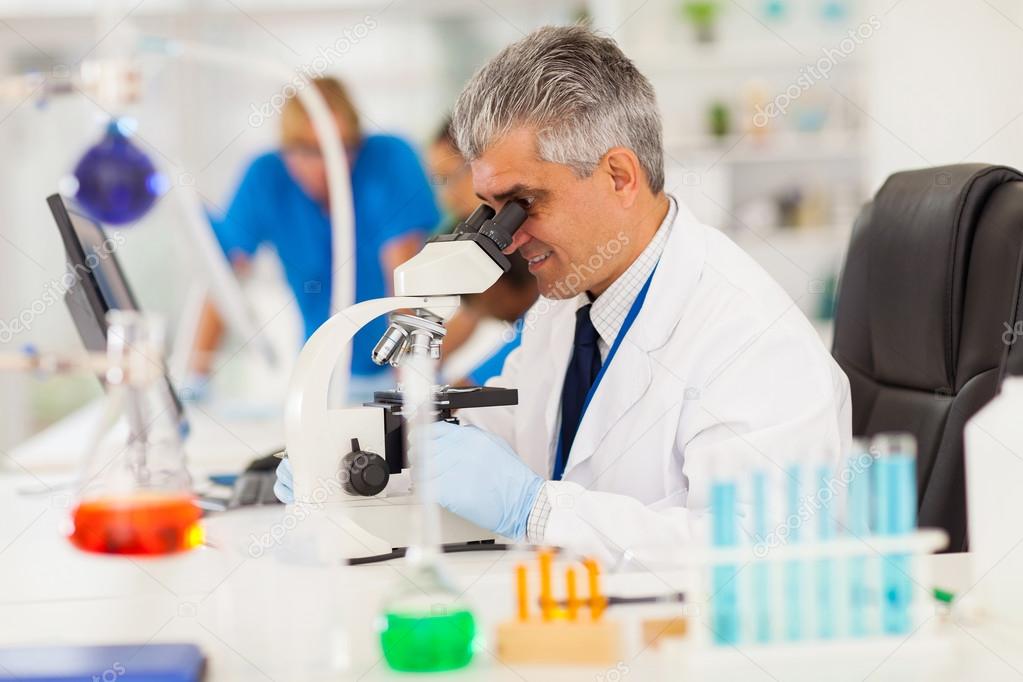 senior medical researcher looking through the microscope