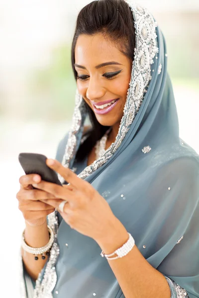 Smiling indian woman reading emails on smart phone — Stock Photo, Image