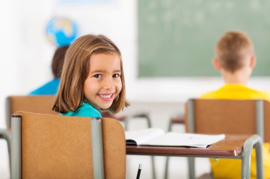 adorable little schoolgirl in classroom clipart