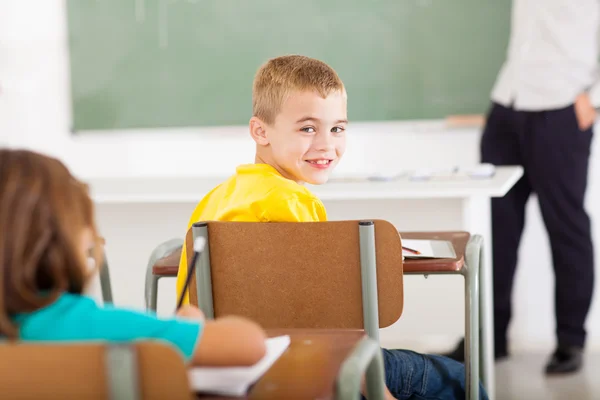 Primary school student looking back in classroom — Stock Photo, Image