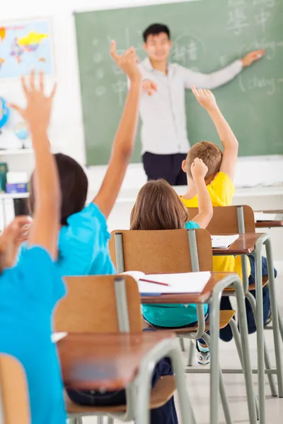 Chino profesor de idiomas en el aula señalando a los estudiantes que rais — Foto de Stock