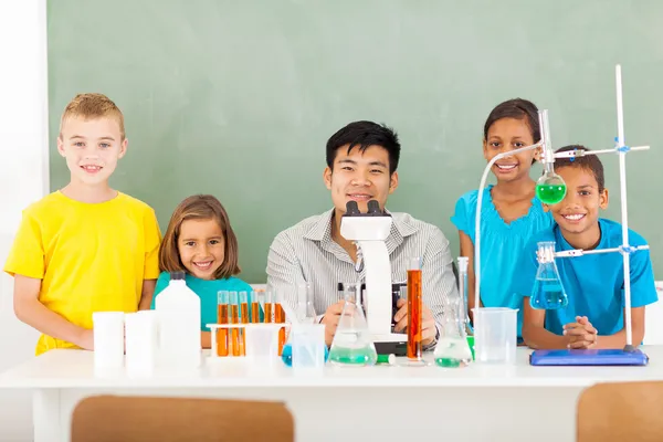 Elementary schoolstudenten en leraar in een science klasse — Stockfoto