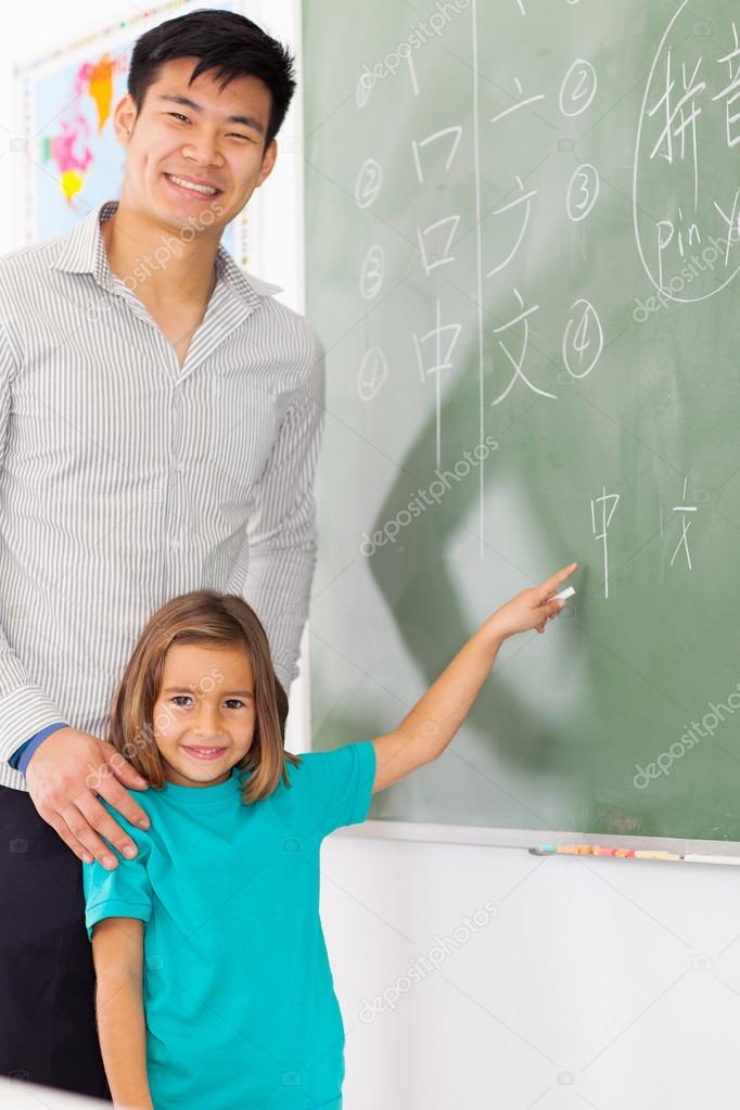 preschool girl pointing chinese language answer on chalkboard