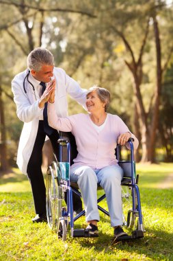cheerful senior patient doing high-five with caregiver