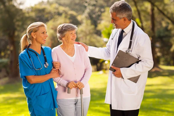 Manliga läkare talar till återvinna äldre patient — Stockfoto