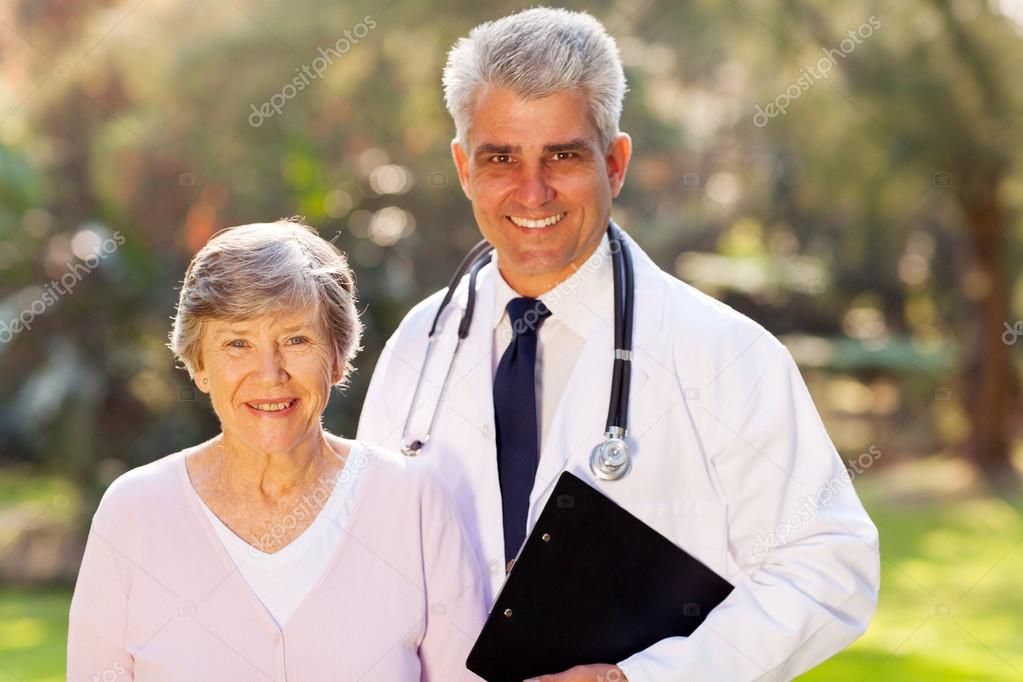 Middle aged doctor and senior patient outdoors