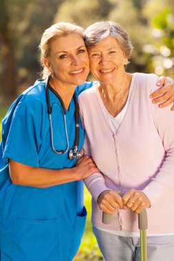 Caregiver kucaklama kıdemli hastaya açık havada
