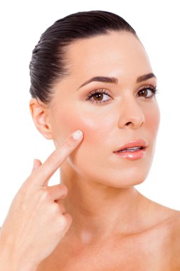 yanağını işaret eden güzel bir kadın